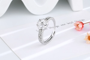 Macro shot of silver ring featuring heart-shaped zircon petals and hollow carved details