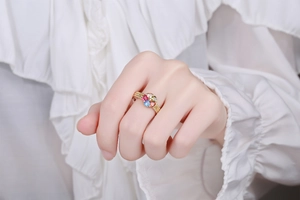 Detail of vintage flower ring with colorful heart-shaped stones on model's finger