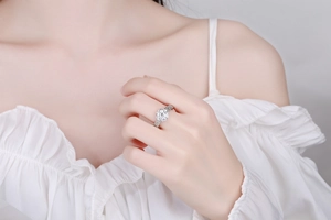 Detailed close-up of a silver floral ring with zircon stones on a model's hand