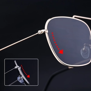 Detail view of gold metal hinges and dark lens curvature on square frame sunglasses