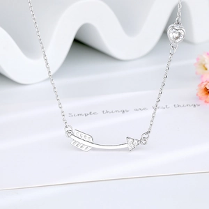 Arrow and heart silver-tone necklace with clear zircon stone on a white display card