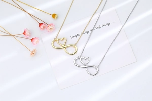 Detailed view of infinity heart pendant necklace in gold and silver on display