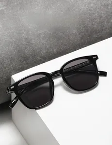 Close-up of square black sunglasses with silver rivets and detailed metallic hinge
