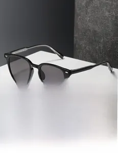 Detail of square black frame sunglasses featuring metallic accents on a white display pedestal
