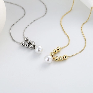 Minimalist pearl pendant necklace set in gold and silver finish on white background