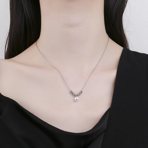 Minimalist pearl necklace on model showing elegant drape and polished metallic beads