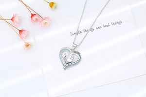 Close-up of heart necklace with blue zircon and engraved I love you to the moon and back
