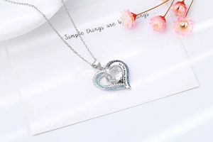 Detail of heart pendant necklace with circular zircon and I love you to the moon engraving