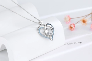 Macro shot of silver heart necklace with blue zircons and I love you engraving