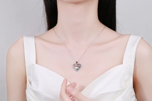 Silver heart necklace with blue and white zircons worn on a model with white V-neck