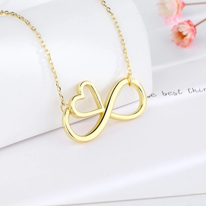 Elegant gold infinity heart pendant necklace with polished finish on a minimalist display