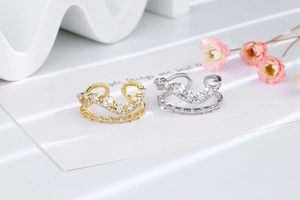 Detail of layered gold and silver wave rings featuring sparkling cubic zirconia stones