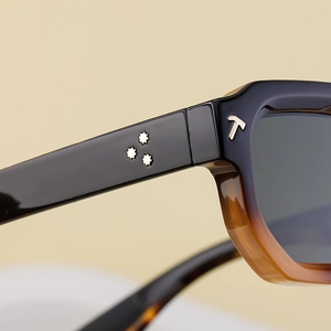 Détail de lunettes avec incrustation en T argentée et trois rivets métalliques en étoile
