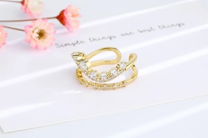 Detail of double-layer wave ring in gold with sparkling white zircon stones