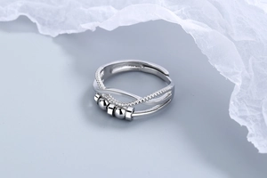 Close-up of triple-layered silver anxiety ring with rotating beads and twisted texture