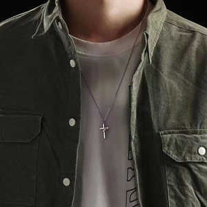 Men's minimalist silver cross necklace with unique wrap design on a casual outfit