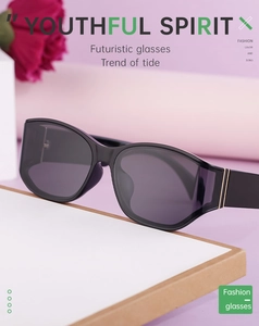 Close-up of futuristic black wrap sunglasses with purple lenses and gold accents