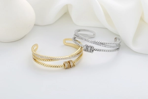 Detailed view of layered gold and silver bangles with micro-pave zircon and rotating beads