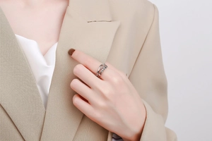 Close-up of a silver multi-layer crossover ring with beads worn on a model's finger