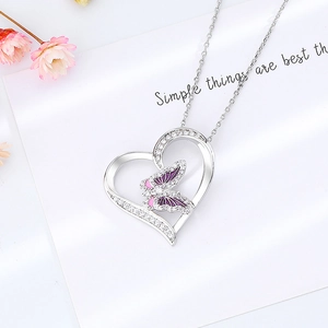 Collier cœur élégant avec papillon violet et cristaux étincelants sur papier blanc