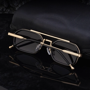 Gros plan de lunettes de soleil rétro en métal doré avec verres noirs et étui