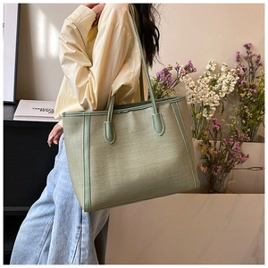 Gros plan du sac cabas vert sauge avec texture tissée et poignées en cuir