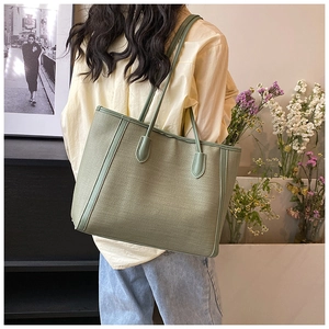 Détail du sac cabas vert sauge montrant la texture tissée et la bandoulière