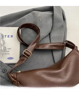 Detail of adjustable brown leather strap and gold buckle on a retro crossbody bag