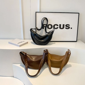 Three half-moon hobo bags in black, dark brown and light brown PU leather on steps
