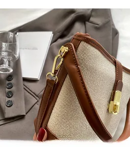 Detail of vintage beige canvas and brown leather bucket bag with gold metallic clasp