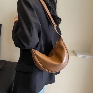 Detailed view of the brown crescent moon bag showing premium PU texture and wide strap