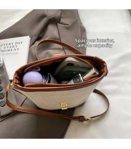 Detailed interior of contrast canvas bucket bag showing capacity for phone and perfume