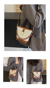 Detail of vintage canvas bucket bag with brown leather trim and golden metal clasp lock