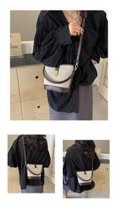 Detailed view of canvas and brown leather bucket bag with gold-tone twist lock closure