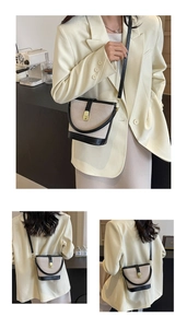 Detail of beige canvas and black leather bucket bag shown on model in cafe setting