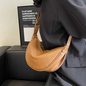 Detail of soft vintage brown croissant bag showing distressed leather texture on the strap