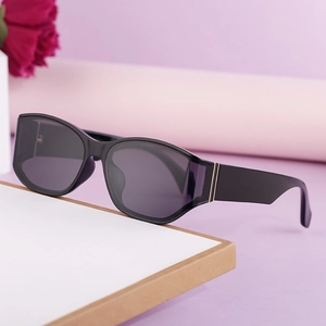 Fashionable curved black sunglasses for women with gold stripes on temples for outdoor style