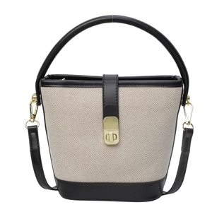 Chic canvas bucket bag with black leather trim and gold twist lock in minimalist style