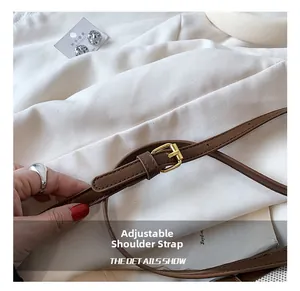 Detail showing adjustable brown leather strap with a polished golden square pin buckle