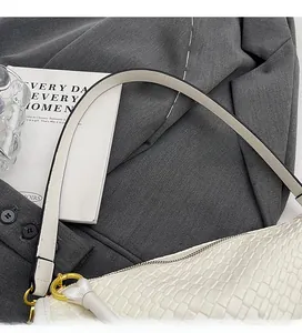Detail of comfortable white embossed leather handle with elegant gold metal buckles