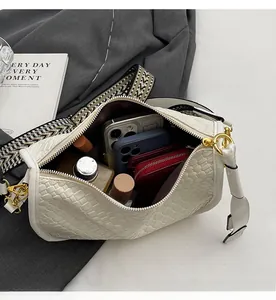 Detailed view showing internal capacity of white woven crossbody bag with wide strap