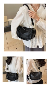 Detail of black embossed rhombic crossbody bag with wide ethnic style woven shoulder strap