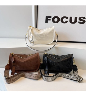 Detailed view of textured half-moon crossbody bags with ethnic style wide straps in three colors