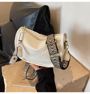 Close-up of white woven leather hobo bag with a decorative geometric jacquard strap