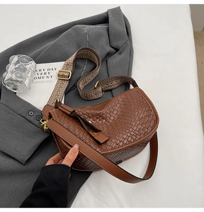 Close-up of brown embossed hobo bag with ethnic jacquard strap and leather strap