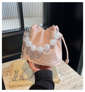 Détail du sac seau rose clair à motif marbré avec poignée perle et bandoulière