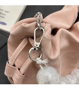 Gros plan du sac seau rose scintillant avec ferrures argentées et perle décorative