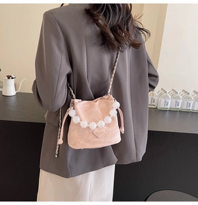 Détail du sac seau plissé rose avec poignée en perles et bandoulière en chaîne