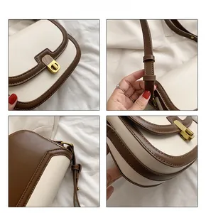 Detail view of retro saddle bag showing golden clasp, stitching and leather strap