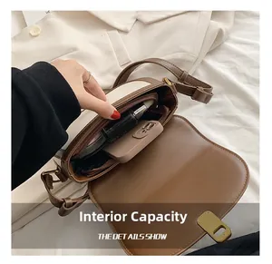Interior view of brown and cream crossbody bag showing capacity for phone and lipstick